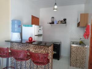 cocina con nevera y barra con sillas en Flat e Suítes Praia de São Bento, en Maragogi