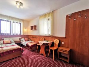 Habitación de hotel con 2 camas y mesa en Dom Gościnny Skalnica en Poronin
