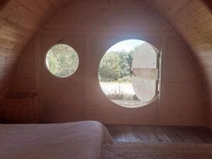 a bedroom with two circular windows in a room at Quinta Alada in Montemor-o-Novo