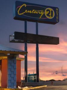 um sinal para um posto de gasolina na Califórnia ao pôr-do-sol em Century 21 Motel em Las Cruces