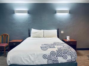 a bedroom with a large bed with two tables and two lamps at Century 21 Motel in Las Cruces