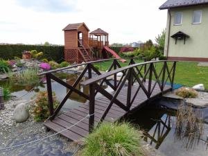 a wooden bridge over a pond in a garden at Irys 1 in Tychy