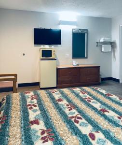 een hotelkamer met een bed en een flatscreen-tv bij Century 21 Motel in Las Cruces