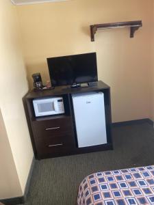 a room with a microwave and a tv on a counter at All Seasons Motel in Port Elgin +11 photos