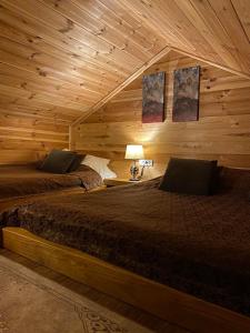 a bedroom with two beds in a log cabin at Princess Nina Kolašin in Kolašin