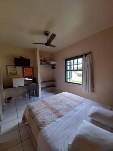 a bedroom with a large bed and a window at Pousada Villa Harmonia in Paraty