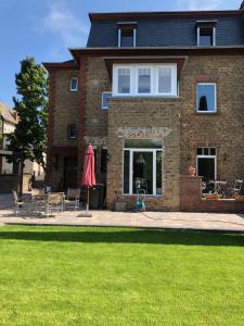 a brick house with a patio and a lawn at L11 Ferienwohnung in Lahnstein