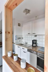 a kitchen with white cabinets and a wooden counter top at Ferienwohnung Alpenfreude in Missen-Wilhams