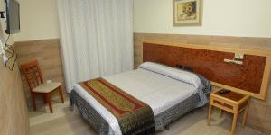 een slaapkamer met een bed en een tafel en stoel bij Domus Viatoris in Sahagún