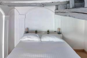 a white bed with two pillows in a room at L'Arpajonnais 1 Cosy Hyper Centre 5min N20 in Arpajon