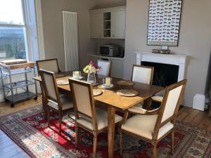1 Georges Place Bath في باث: غرفة طعام مع طاولة وكراسي خشبية