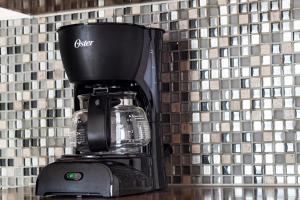 a black coffee maker in front of a tiled wall at +MS +Suite Loft Accesible +Ubicadísimo +Carretera 57 105A in Querétaro