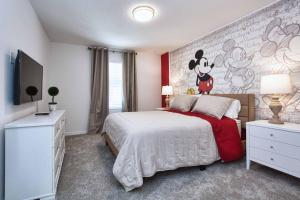 5 Bedrooms Townhome w- Splashpool - 8205SA في أورلاندو: غرفة نوم مع جدارية لفأر ميكي على الحائط