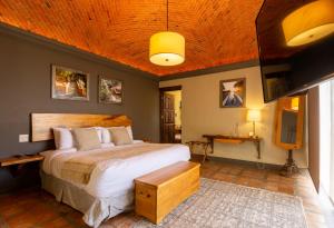 een slaapkamer met een groot bed en een houten plafond bij Hotel Camino de Vinos in Guanajuato