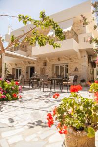 a patio with flowers and tables and chairs at Fantastic Matala 1 in Matala