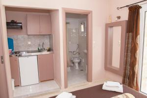a small bathroom with a toilet and a sink and a sink at Fantastic Matala 1 in Matala