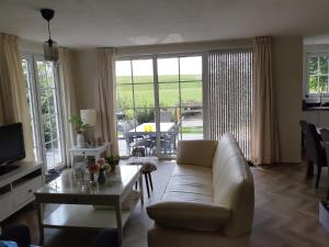 een woonkamer met een bank en een tafel bij Nieuwe Beachbungalow aan IJsselmeer 39 24 four seasons in Lemmer