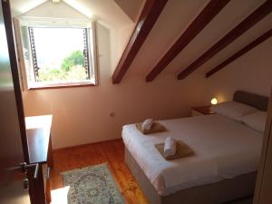 1 Schlafzimmer mit 2 Betten und einem Fenster in der Unterkunft Rest House Stiniva in Podšpilje