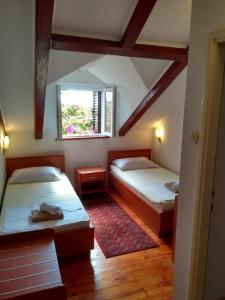 1 Schlafzimmer mit 2 Betten und einem Fenster in der Unterkunft Rest House Stiniva in Podšpilje