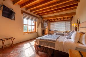 een slaapkamer met 2 bedden in een kamer met houten plafonds bij Hotel Camino de Vinos in Guanajuato