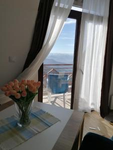 un jarrón de flores en una mesa frente a una ventana en Magic View E16 Kopaonik, en Kopaonik