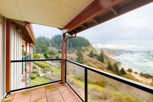 a balcony with a view of the ocean at Rainbow Rock 303 in Brookings