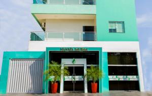 een gebouw met palmbomen ervoor bij Hamara Soft Hotel 2 in Altamira
