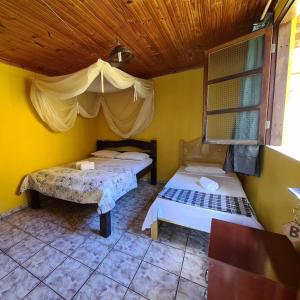 1 dormitorio con 2 camas y techo de madera en Casa da Trilha, en Vale do Capao