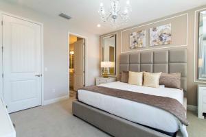 sypialnia z dużym łóżkiem i żyrandolem w obiekcie Beautiful Themed Single Home with Private Pool and Game Room EC0405 w Orlando