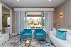 een woonkamer met een witte bank en blauwe stoelen bij Beautiful Themed Single Home with Private Pool and Game Room EC0405 in Orlando