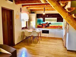 a kitchen with a table and chairs in a room at Domki Eden z Ballią in Gołubie