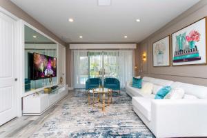 een woonkamer met een witte bank en een tv bij Beautiful Themed Single Home with Private Pool and Game Room EC0405 in Orlando