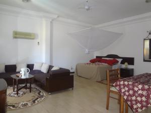 a living room with a couch and a bed at Roc Heights in Bakau