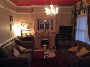 sala de estar con 2 sofás y chimenea en White Lodge Guest House, en Skegness