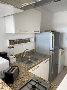 a kitchen with a sink and a refrigerator at Beachfront Loft Amara Cancun in Cancún