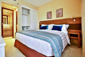 a bedroom with a large bed with blue pillows at Quality Hotel & Suítes São Salvador in Salvador