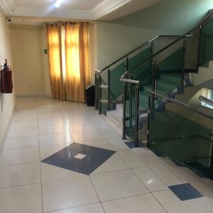a hallway with a staircase and a tiled floor at Korkdam Hotel in Achimota