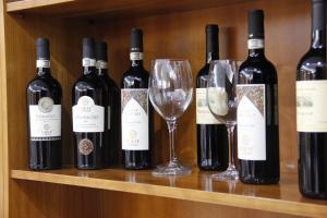 a group of wine bottles and glasses on a shelf at Citta' Dei Papi in Anagni