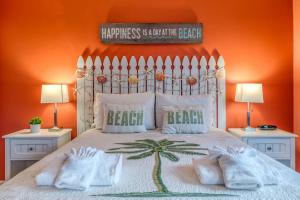 a bedroom with a bed with an orange wall at Driftwood Escape in Saint Augustine Beach