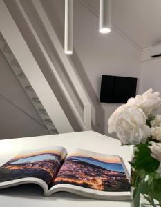 an open book on a table with a vase of flowers at Apartment San Rocco in Stinica