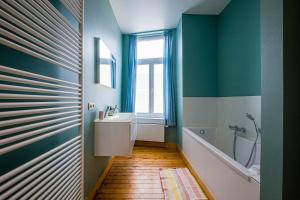 a bathroom with a sink and a tub and a window at Villa Louise Oostende in Ostend +17 photos