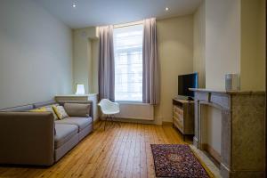 a living room with a couch and a window at Villa Louise Oostende in Ostend