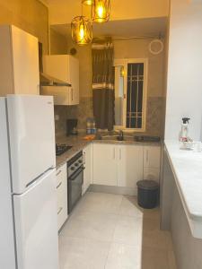 a kitchen with white cabinets and a white refrigerator at Zayatine RDC in Tunis