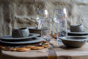 a table with plates and wine glasses on it at Boutique Cottage - Sauna and Jacuzzi - El Clandestino in Érezée