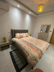 1 dormitorio con cama, tocador y espejo en Zayatine RDC en Túnez