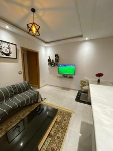 a living room with a couch and a flat screen tv at Zayatine RDC in Tunis