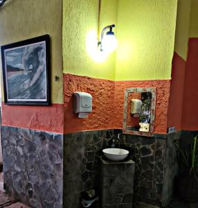 a bathroom with a sink and a colorful wall at Pousada Dalva in Galinhos