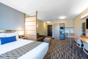 una camera d'albergo con un grande letto e una scrivania di Microtel Inn Suites by Wyndham South Hill a South Hill