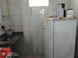 a small kitchen with a white refrigerator and a sink at Apto ProntoCardio Rodoviária in Campos dos Goytacazes