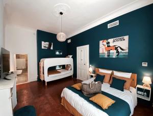 um quarto com uma cama branca e uma parede azul em La Domitia - Maison d'hôtes, spa & massages em Montbazin